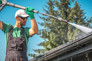 homme utilisant un karcher pour démousser une toiture